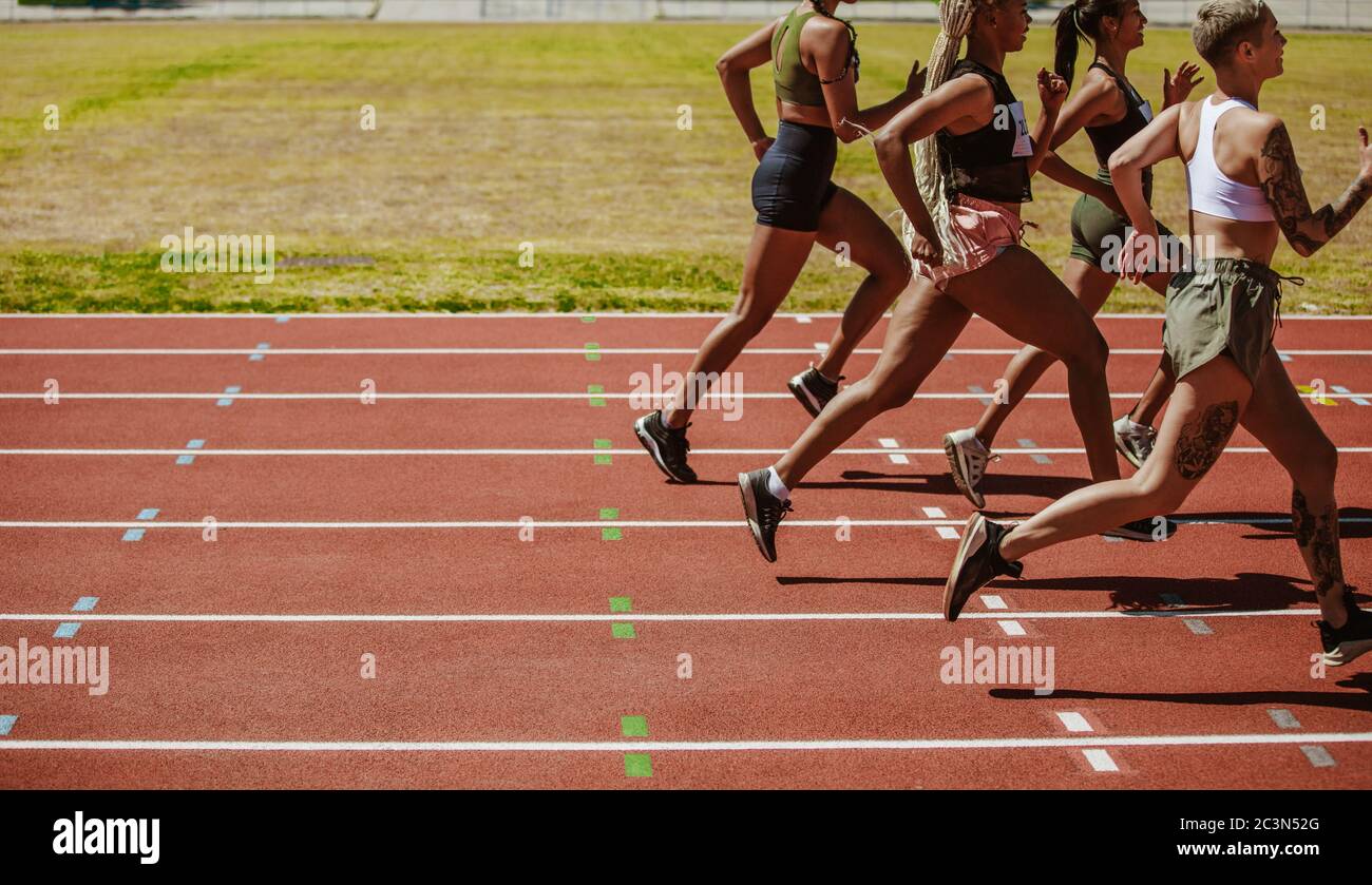 Weibliche Athleten Rennen auf der Strecke. Frauen im Rennen auf Leichtathletik Stadion Strecke. Stockfoto