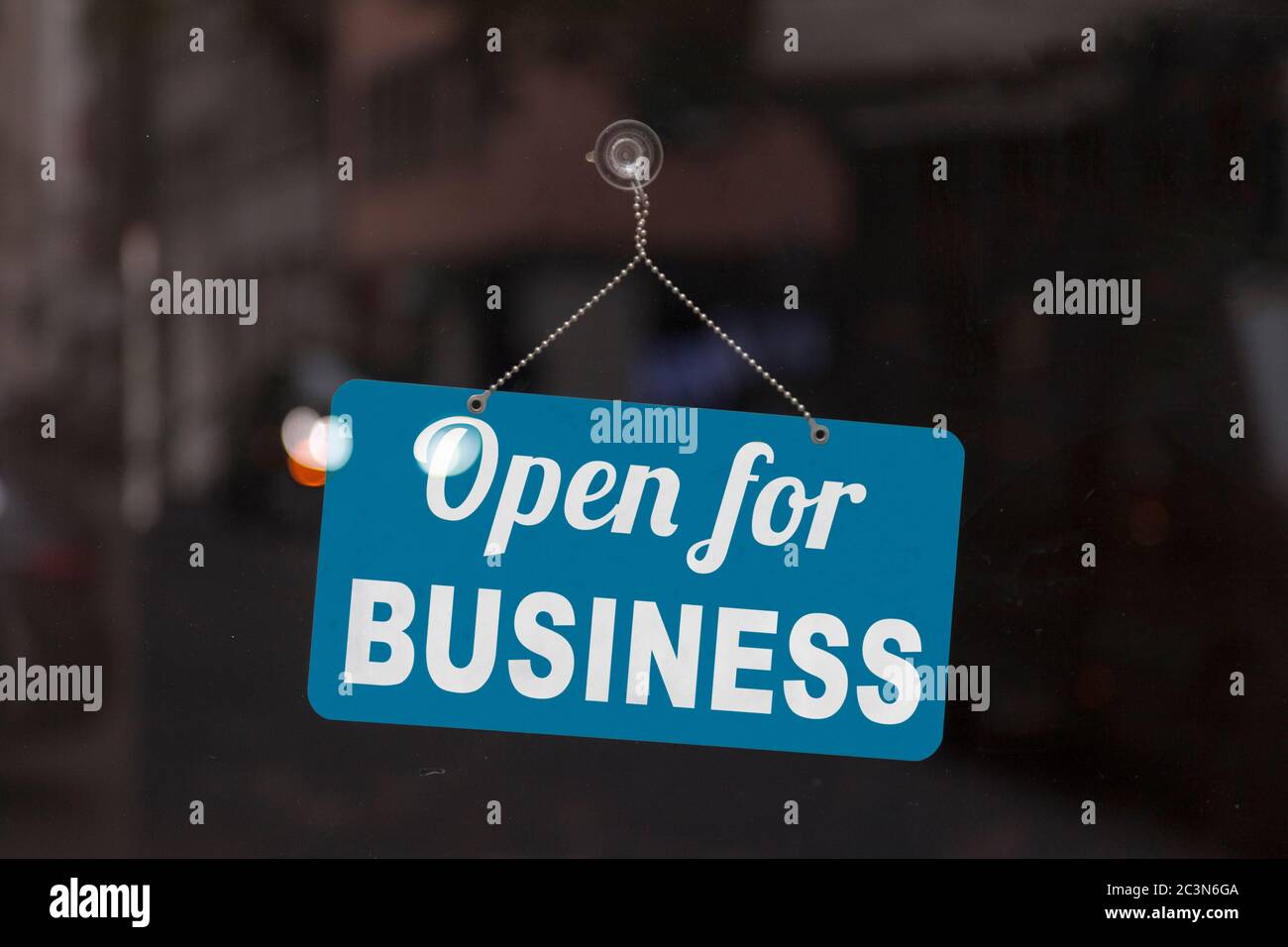 Nahaufnahme eines blauen geöffneten Schildes im Schaufenster eines Ladens mit der Meldung: Open for Business. Stockfoto