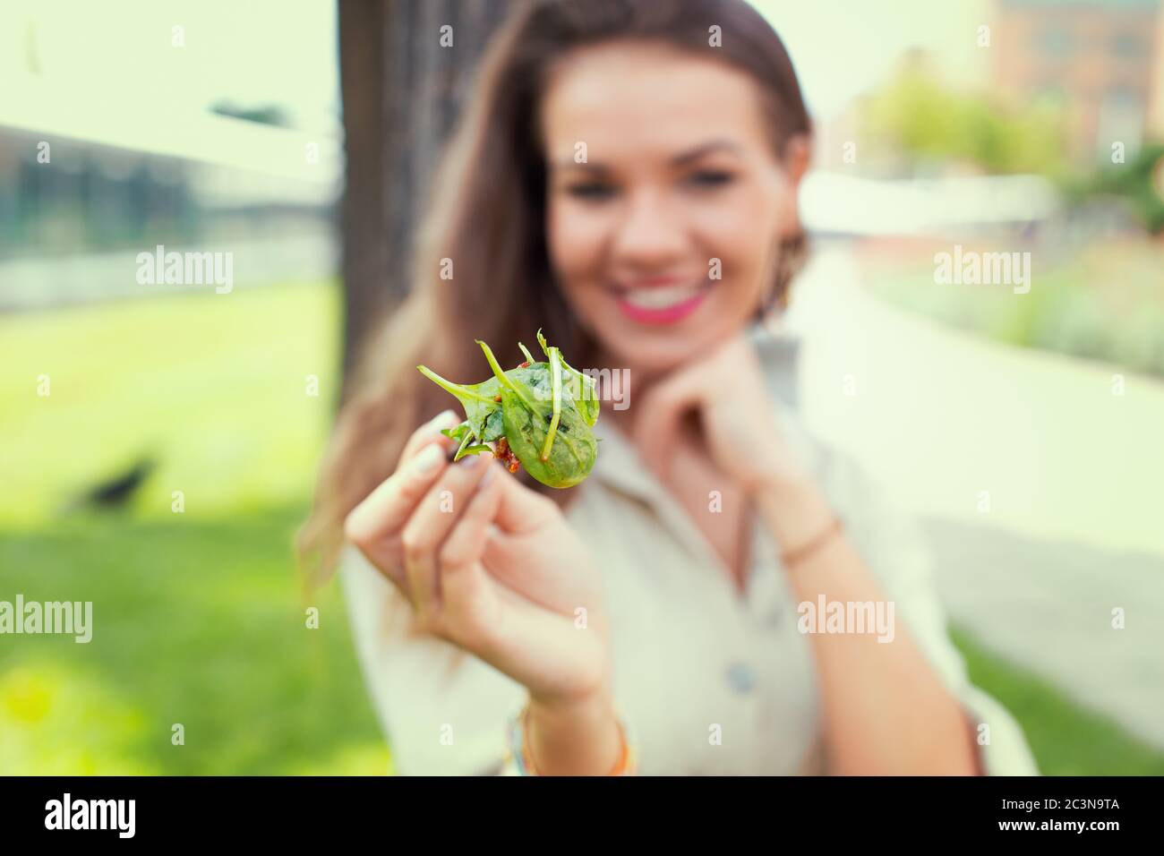 Glückliche junge Latina Frau mit Salat, Tiefe des Feldes Stockfoto