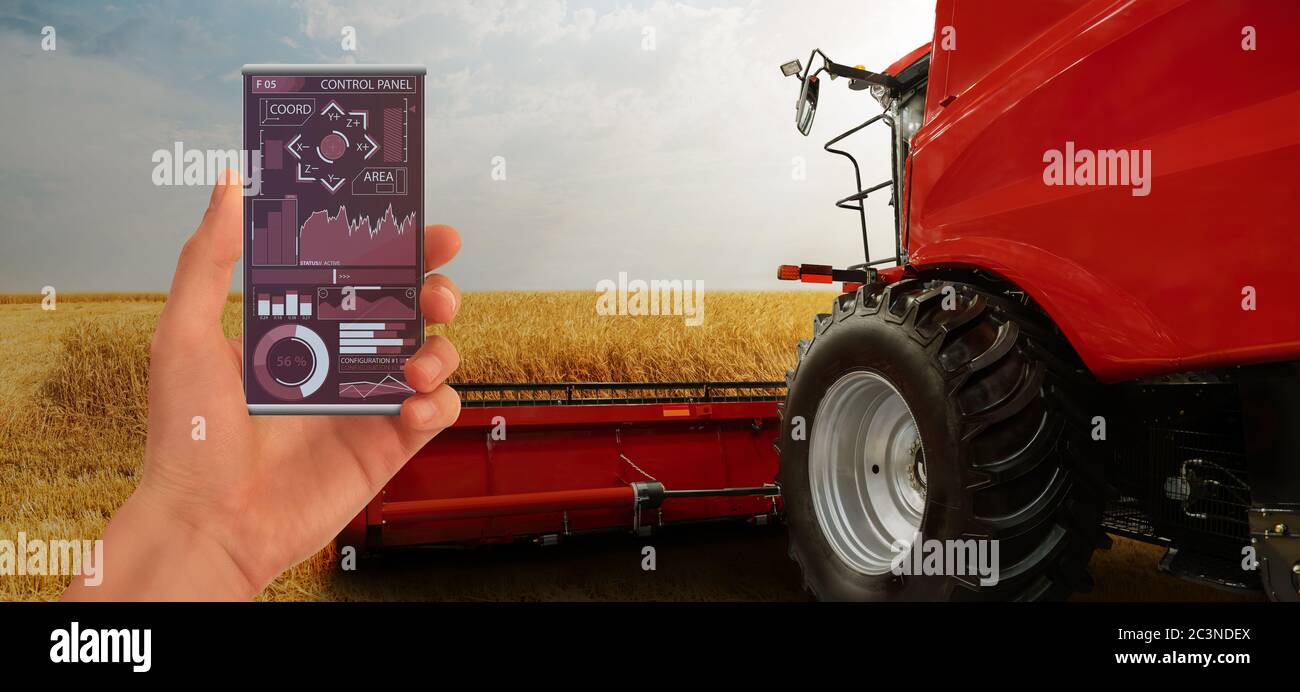 Farmer mit digitalem Tablet steuert einen autonomen Traktor und eine Drohne auf einer intelligenten Farm Stockfoto