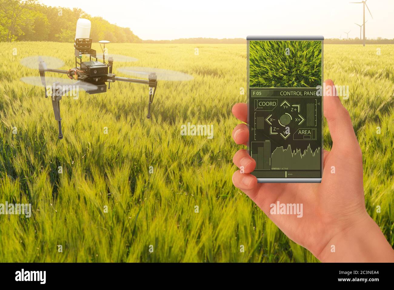 Farmer steuert Drohnensprüher mit einer mobilen App. Intelligente Landwirtschaft und Präzisionslandwirtschaft Stockfoto