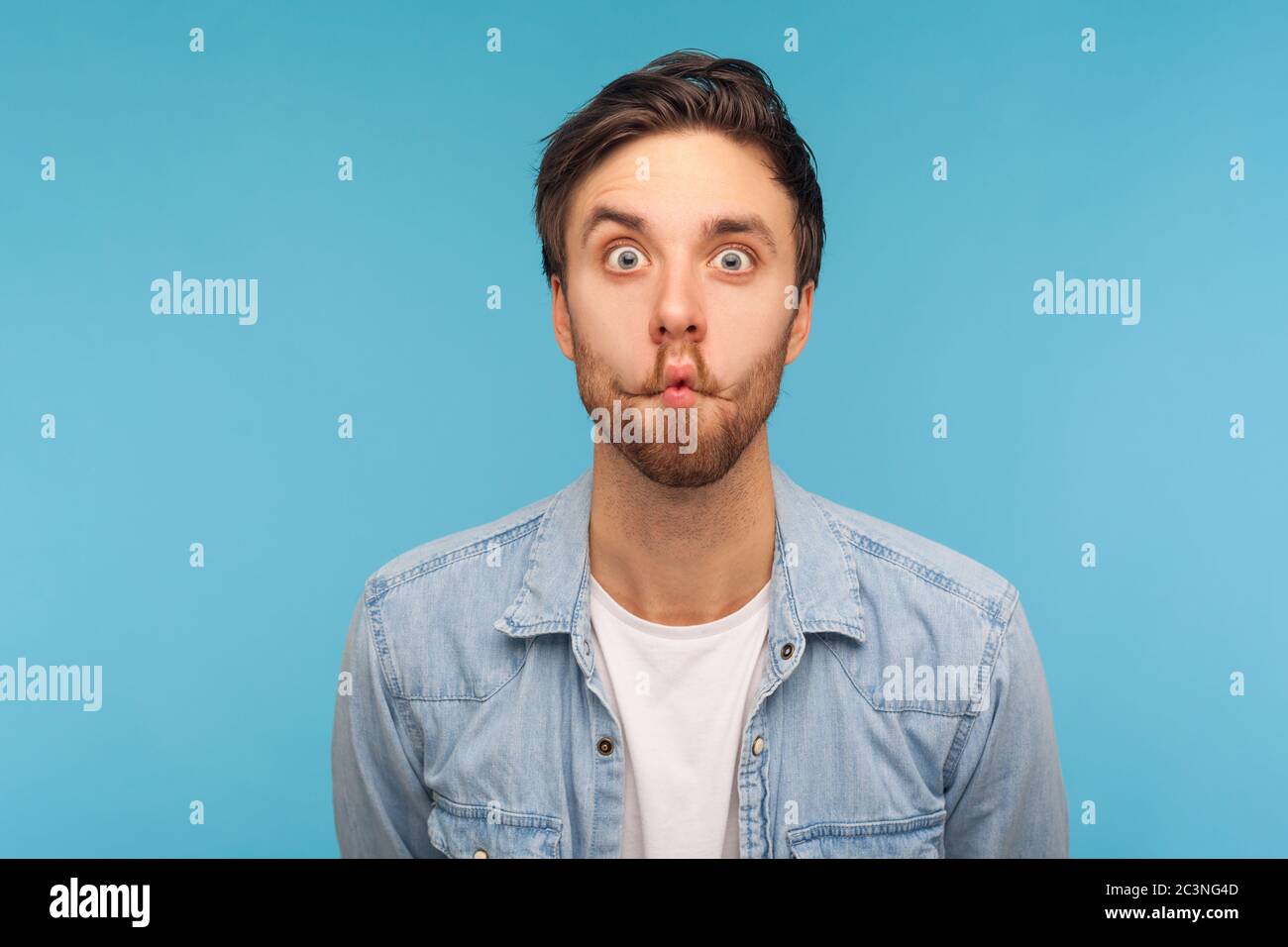 Portrait of humorvoll lustigen Mann in Arbeiter Denim Shirt machen erstaunt Grimace mit komischen Fisch Gesicht, Pout Lippen und überrascht dumm idiotischen Ausdruck. ich Stockfoto