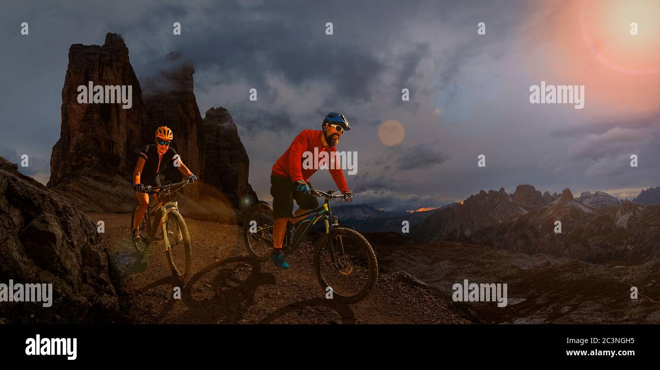 Radfahren Outdoor-Abenteuer in den Dolomiten. Radfahren Frau und Mann auf Elektro-Mountainbikes in der Dolomitenlandschaft. Paar Radfahren MTB Enduro Trac Stockfoto