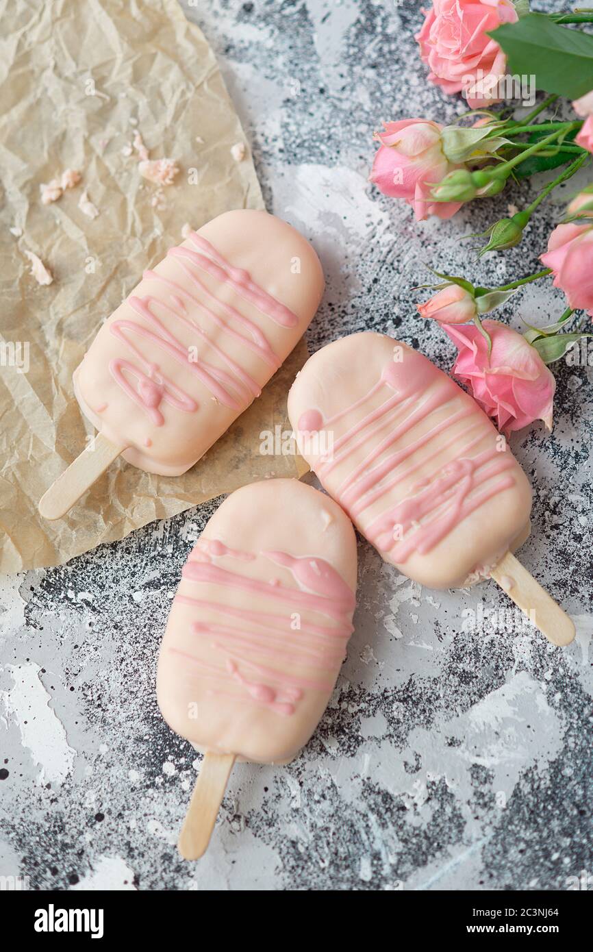 Gourmet-Eis Dessert Kokosnuss-gewürzt Eisschokolade Glasur rosa Schokolade aus einer Bäckerei zu Hause auf grauem Hintergrund. Selektiver Fokus, Kopierbereich. Stockfoto