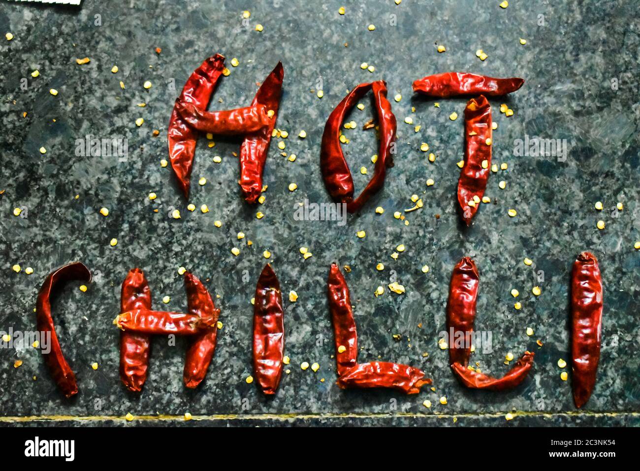 Die roten Chili.Hot Chili wird mit den Chilis selbst mit schwarzem Hintergrund geschrieben Stockfoto