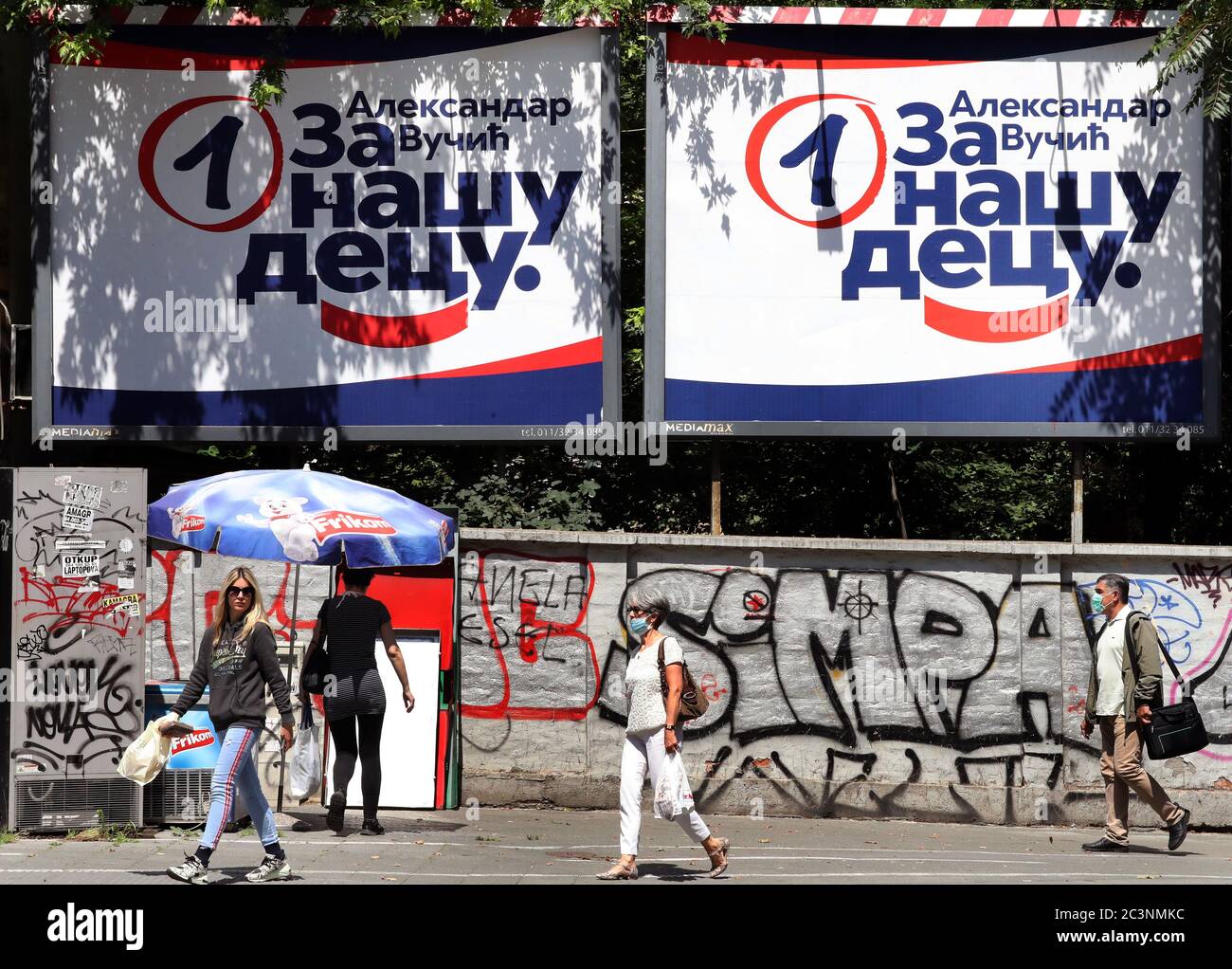 Die Leute kommen an den Plakaten der regierenden Serbischen Fortschrittspartei (SNS) des amtierenden Präsidenten Aleksandar Vucic vor dem bevorstehenden parli vorbei Stockfoto