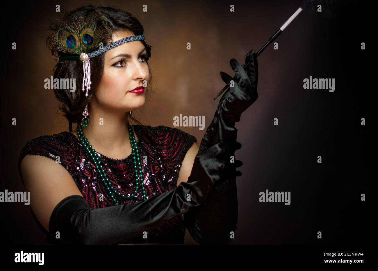 Junge elegante Dame in den goldenen Zwanzigern mit Zigarette Stockfoto