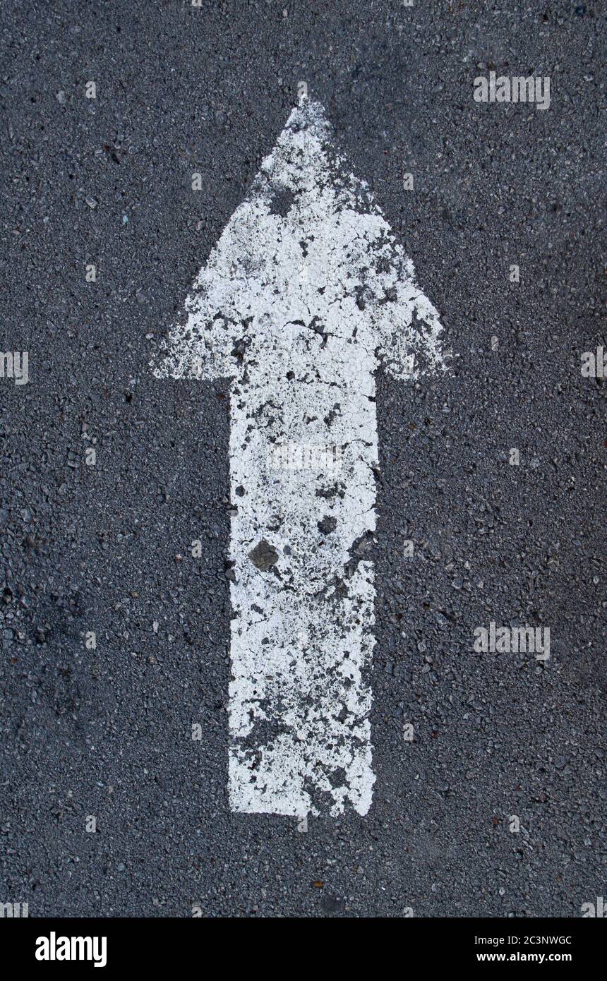 Zeiger Pfeil auf dem Asphalt, weiß verblasste Farbe. Stockfoto