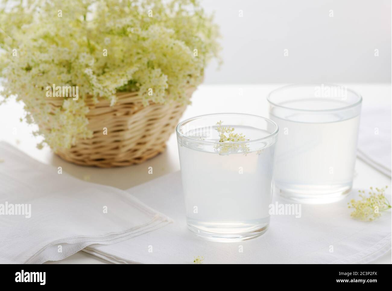 Gesunde erfrischende Holunderblütenlimonade und Holunderblüte auf weißem Hintergrund.Bild mit selektivem Fokus, horizontal. Stockfoto
