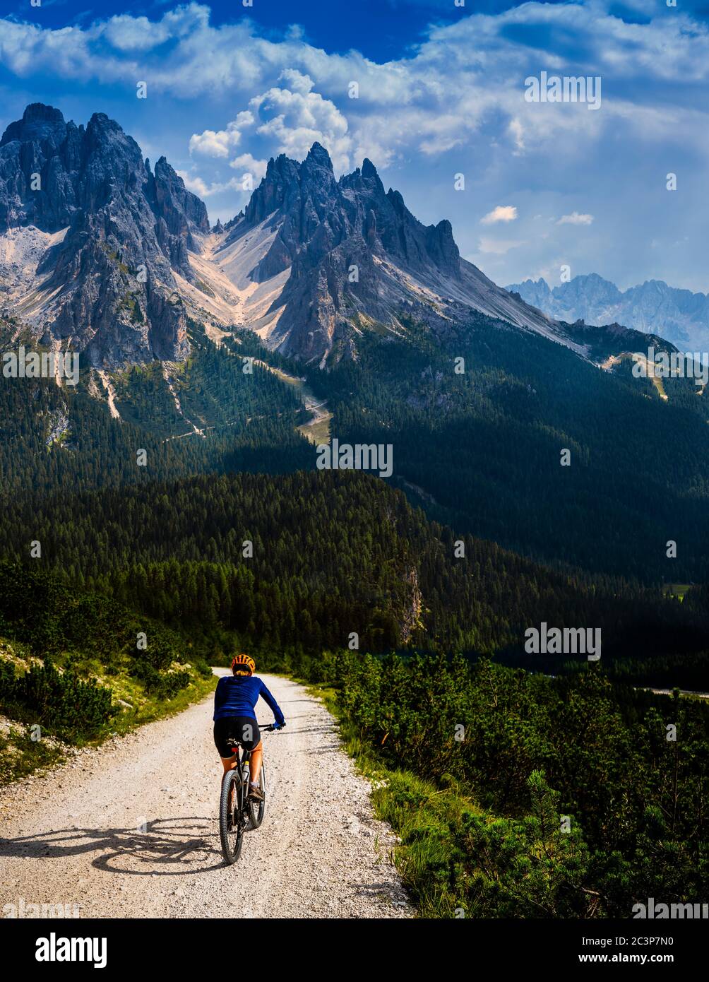 Touristisches Radfahren in Cortina d'Ampezzo, atemberaubende felsige Berge im Hintergrund. Frau auf dem MTB Enduro Flow Trail. Südtirol Provinz Italien, D Stockfoto