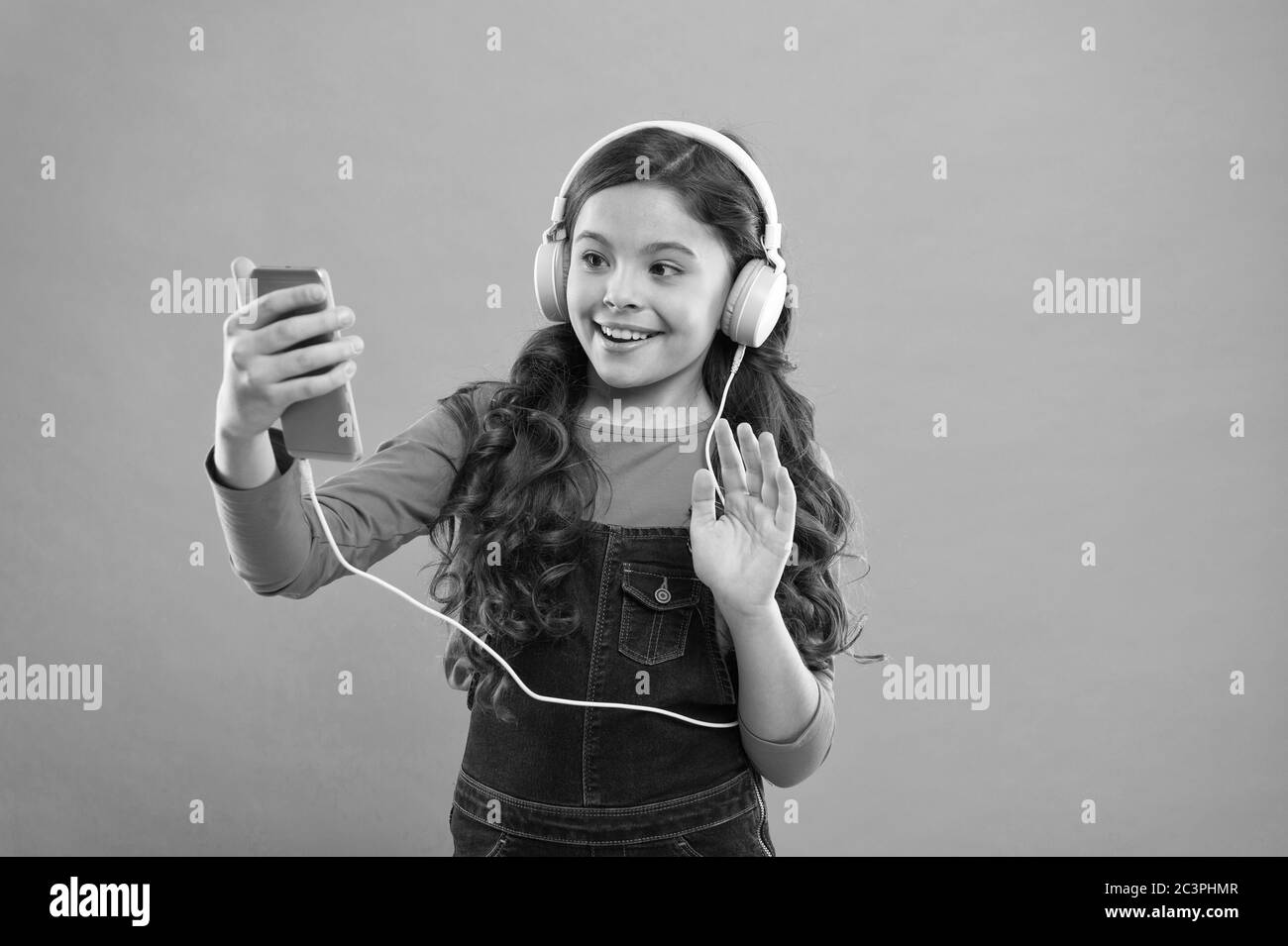Hallo. Langes Haar für Kinder machen selfie im Headset. Kleines Kind  erstellen Spielliste auf Smartphone. Kleines Mädchen verwenden MP3-Player.  Studieren im modernen Leben. Schulmädchen verwenden digitales Gerät.  Freizeit für Kinder Stockfotografie -