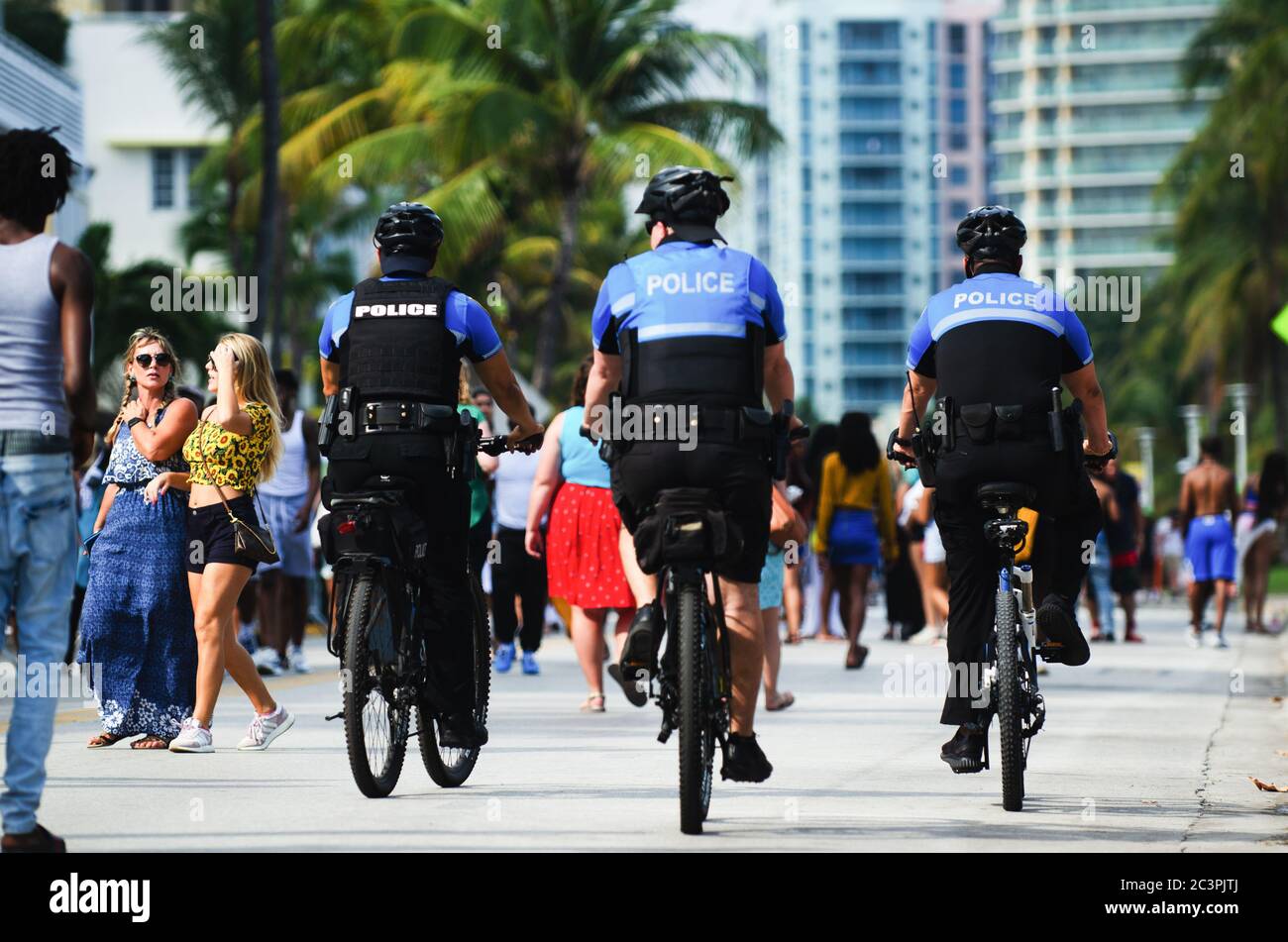 MIAMI - 17. MÄRZ 2019: Polizei auf dem Fahrrad fährt auf Ocean Drive, während sich junge Leute in South Beach für die jährlichen Frühlingsferien von der Schule versammeln. Stockfoto