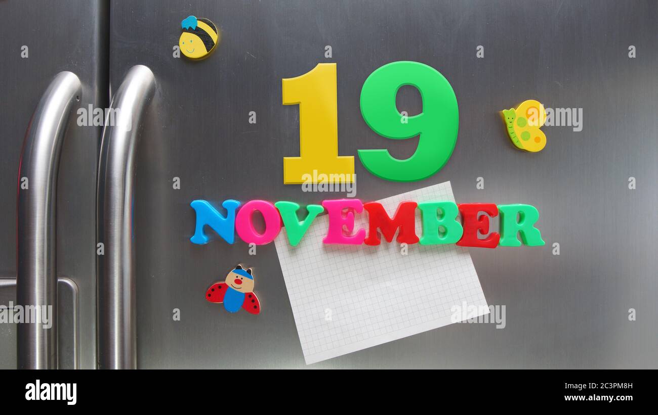 Kalenderdatum November 19 mit magnetischen Plastikbuchstaben mit einer Notiz von Graphitpapier auf Tür Kühlschrank gemacht Stockfoto