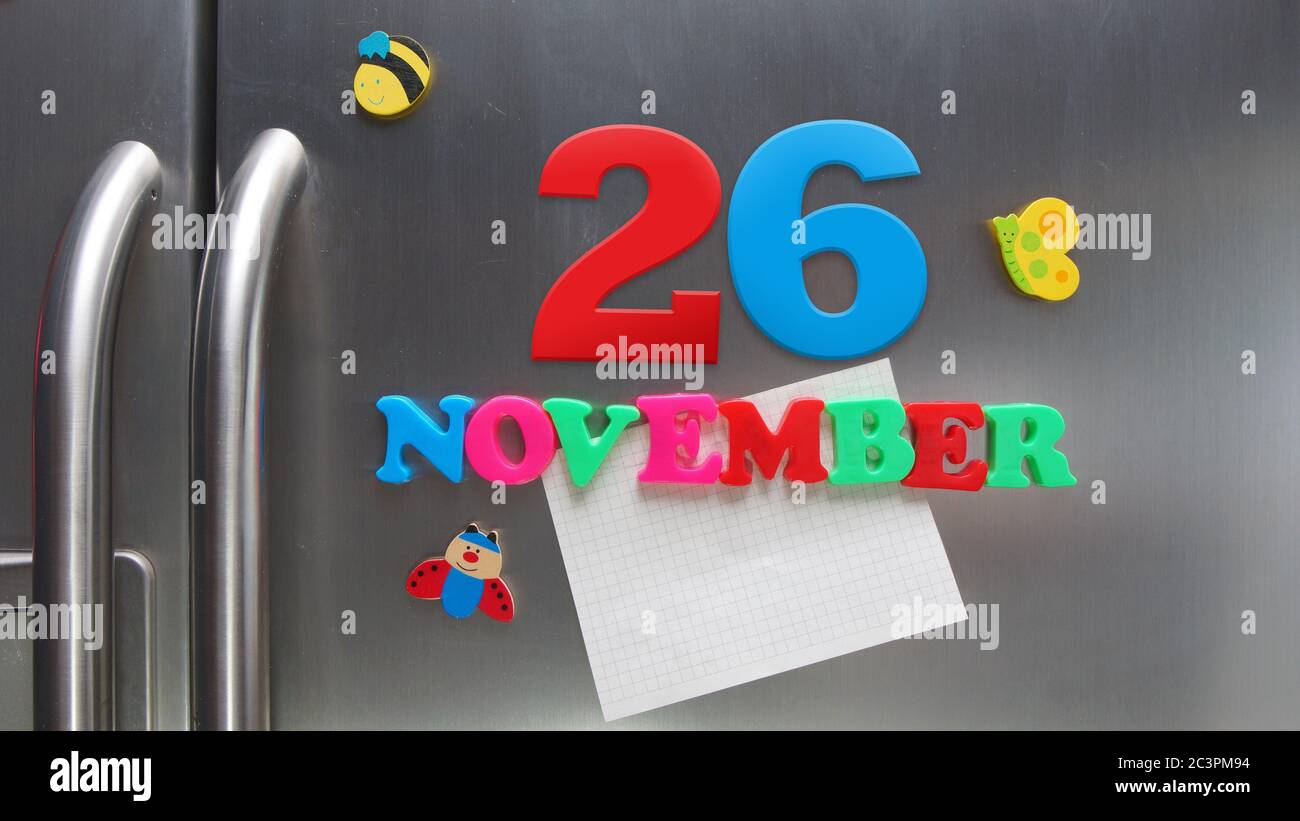 Kalenderdatum November 26 mit magnetischen Plastikbuchstaben mit einer Notiz von Graphitpapier auf Tür Kühlschrank gemacht Stockfoto
