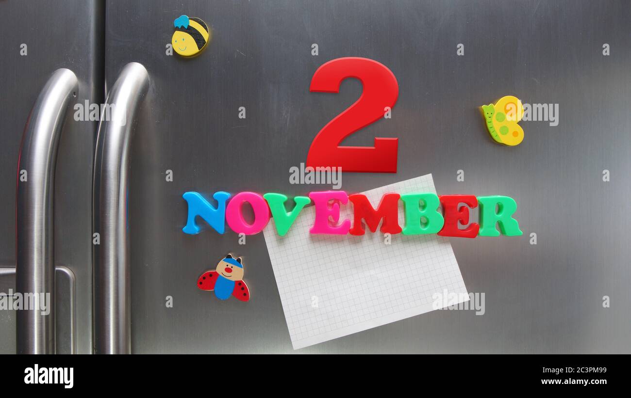 Kalenderdatum vom 2. November mit magnetischen Plastikbuchstaben, die eine Notiz von Graphitpapier auf dem Türkühlschrank halten Stockfoto