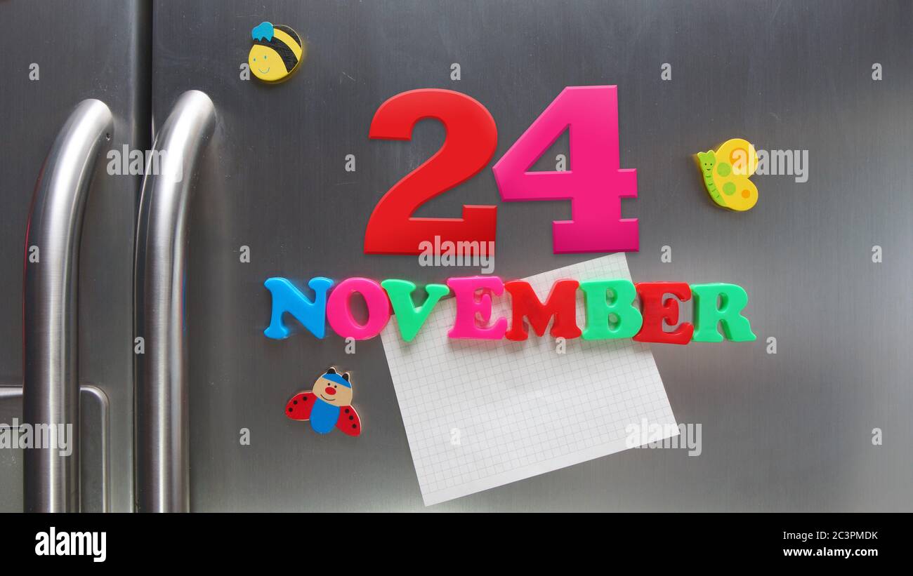 Kalenderdatum November 24 mit magnetischen Plastikbuchstaben mit einer Notiz von Graphitpapier auf Tür Kühlschrank gemacht Stockfoto