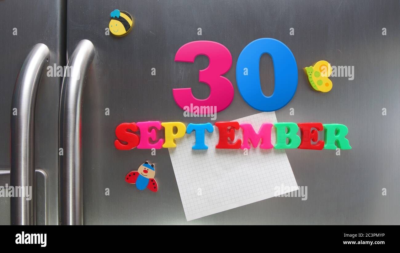 September 30 Kalenderdatum mit Kunststoff-Magnetbuchstaben mit einer Notiz von Graphitpapier auf Tür Kühlschrank gemacht Stockfoto