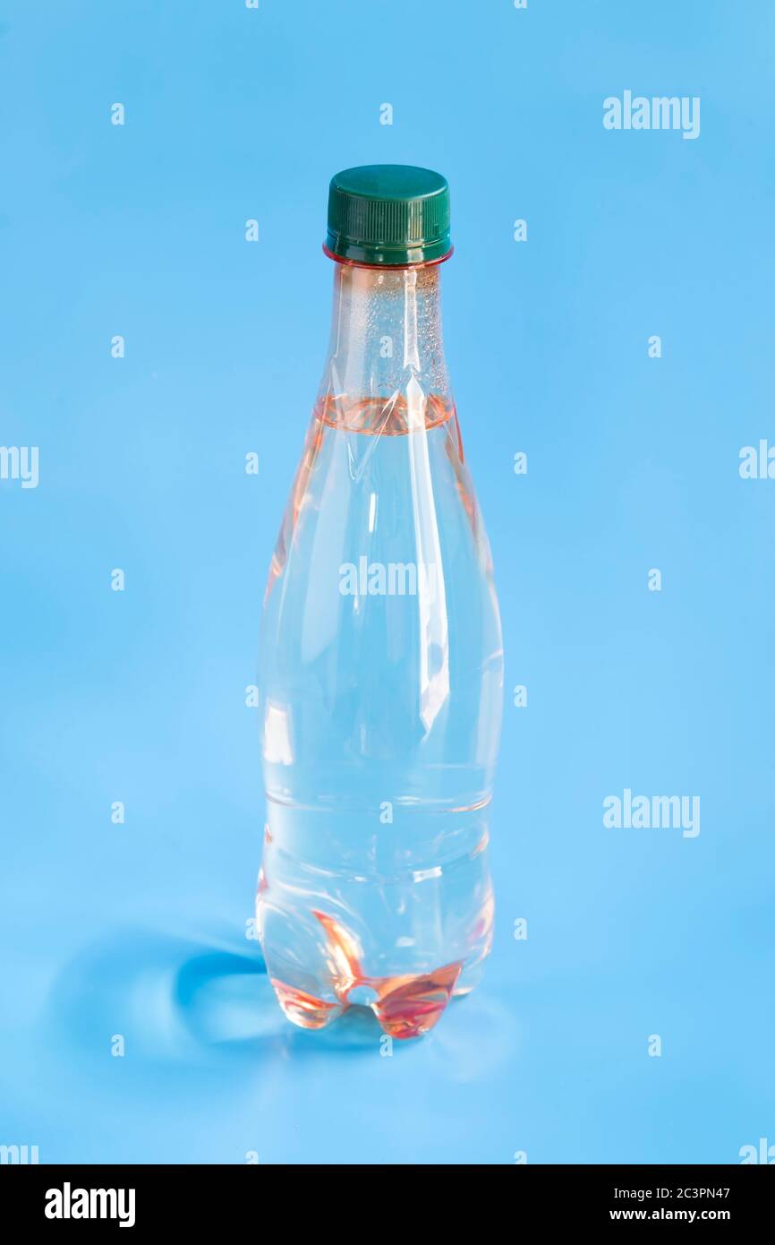 Flasche Mineralwasser auf blauem Hintergrund Stockfoto