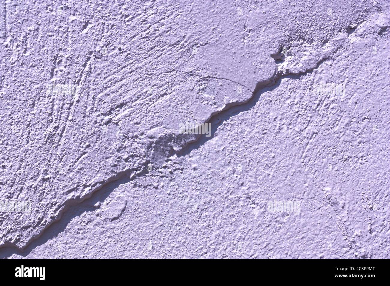 Weiße Wand mit einer rauen Form darauf, die eine Diagonale bildet, die das Bild in zwei Teile teilt Stockfoto