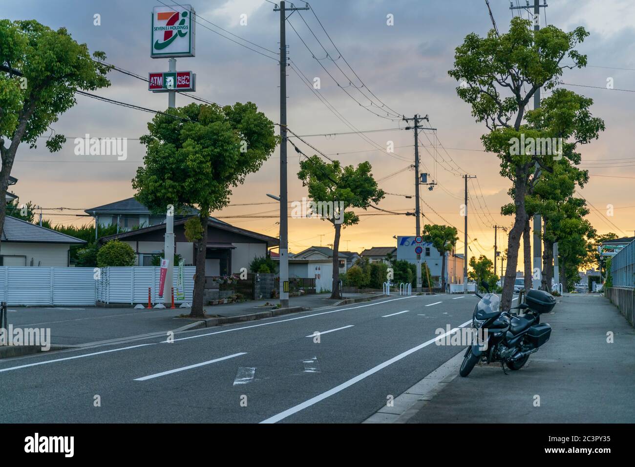 Kobe, Japan - 19. Juni 2020: Motorrad auf leerer Straße vor dem Supermarkt bei Sonnenuntergang geparkt Stockfoto