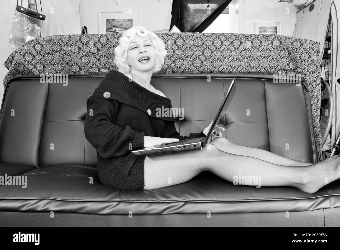 Moderne nehmen Marilyn, Retro-Stile, Vintage-Stile, Periode Stile. Marilyn Monroe Satire, frustriert mit ihrem Laptop in ihrem chaotischen Haus Stockfoto