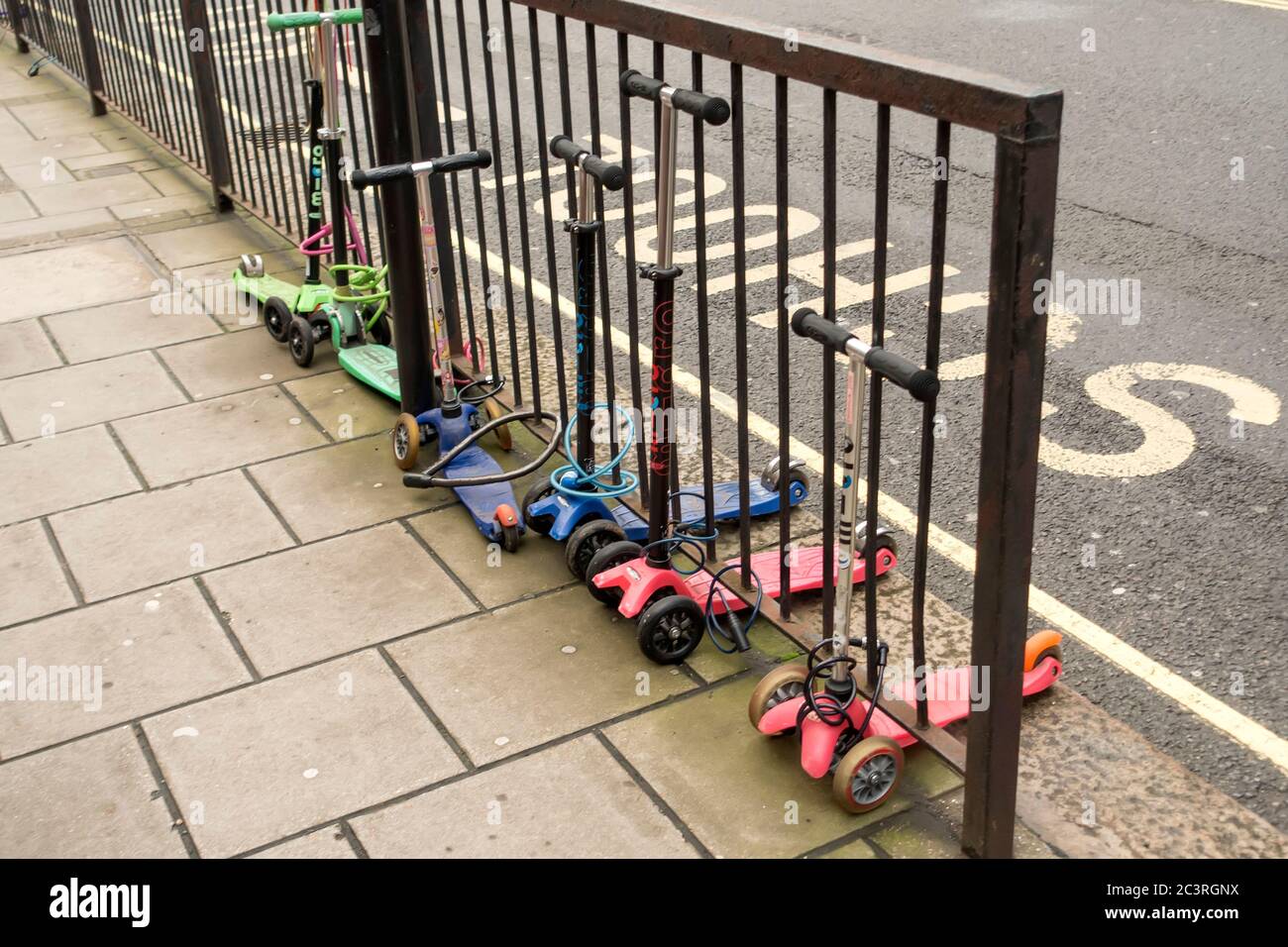 Kinderroller vor der Schule, London, Großbritannien, gebunden Stockfoto