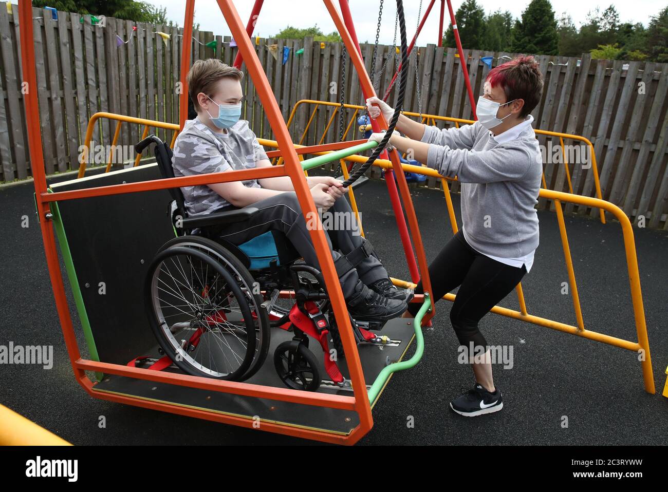 Gregor Marshall hat neben der frühen Praktikerin Catherine Anderson als Gregor eine Fahrt mit der Rollstuhlschaukel im aussen Therapiebereich des Craighalbert Centers. Coronavirus-Anpassungen wurden im Scottish Centre for Children with Motor Impairments, Craighalbert Centre, Cumbernauld, installiert, da Schottland die Maßnahmen zur Sperrung des Coronavirus schrittweise aufhebt. Stockfoto