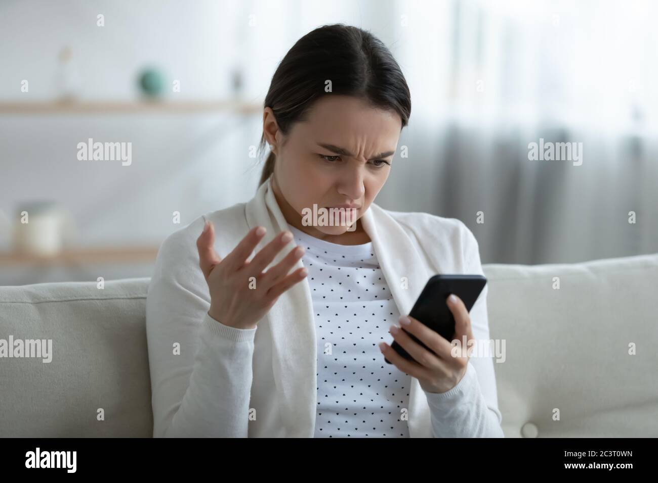 Irritierte Frau hält Smartphone mit Problemen mit Gadget fühlt sich genervt Stockfoto