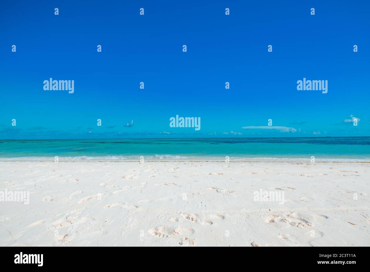 Weißer Sandstrand mit türkisfarbenem Wasser und blauem Himmel. Strandlandschaft, tropisches Naturmuster mit Kopierraum. Friedlich, entspannen, ruhige Aussicht Stockfoto