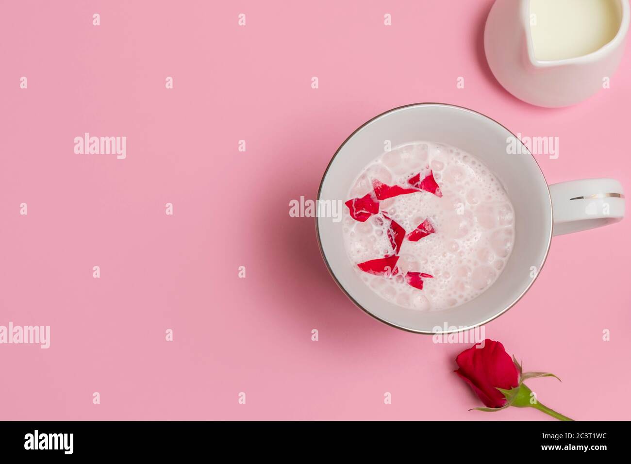 Tasse Rose Cardamom Almond Moon Milk (rosa Mondmilch) auf pastellrosa Hintergrund. Overhead-Ansicht mit Platz für Text Stockfoto