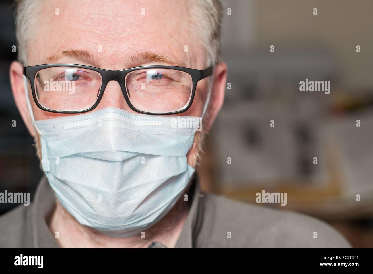 Porträt eines Mannes mit Brille und medizinischer Maske. Das Konzept des Schutzes und der Prävention von Viren- und Infektionskrankheiten. Leerzeichen für Text. Stockfoto