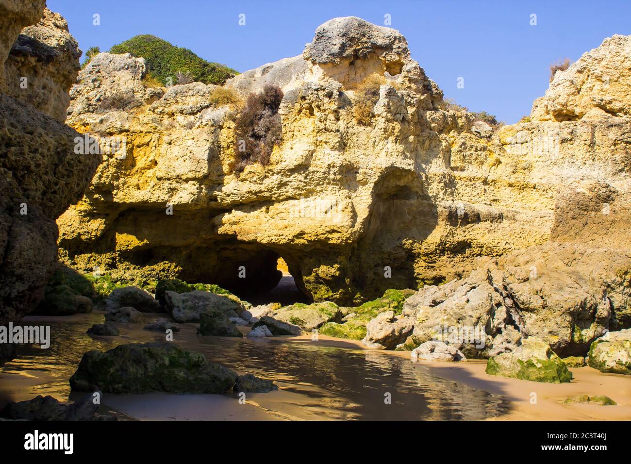 Eine einsame Bucht entlang des Strandes Oura Praia an der Algarve Portugal in der Nähe von Albuferia, die verwitterte Felsen und Winderosion zeigt. Stockfoto
