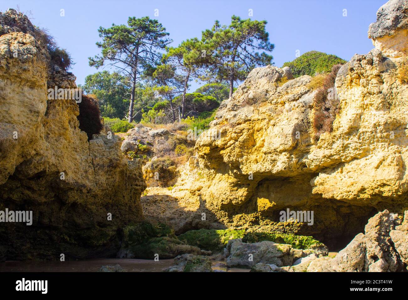 Eine einsame Bucht entlang des Strandes Oura Praia an der Algarve Portugal in der Nähe von Albuferia, die verwitterte Felsen und Winderosion zeigt. Stockfoto