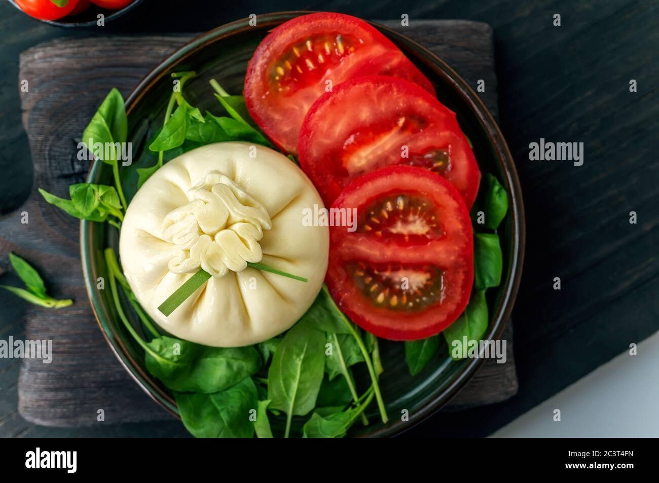 Burrata. Abendessen mit Tomaten und Spinat Salat mit italienischem Buratto Käse. Konzept der gesunden mediterranen Küche. Stockfoto