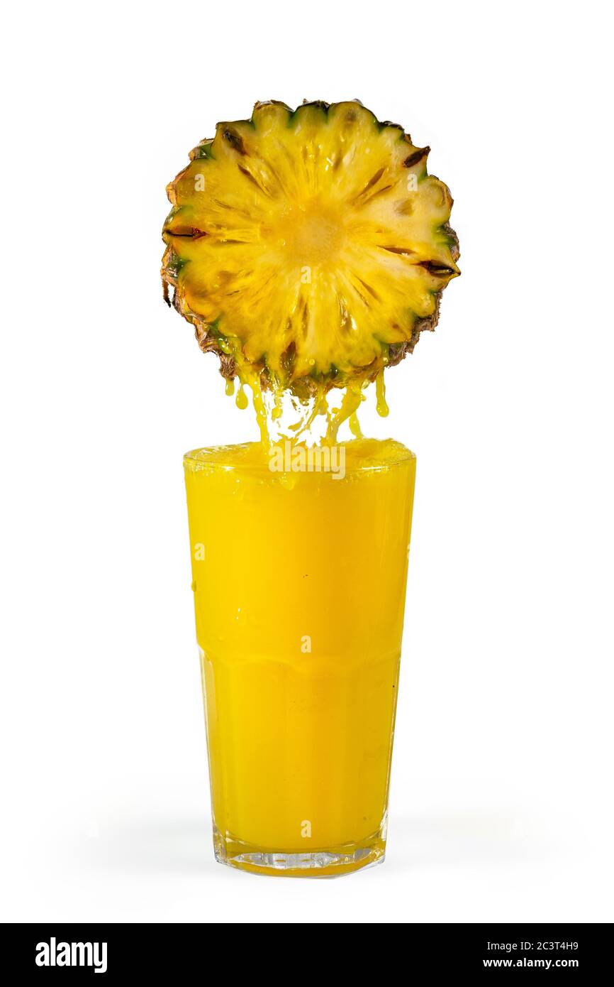 Ananas mit fließendem Saft in einem Glas. Isoliert auf weißem Hintergrund. Stockfoto