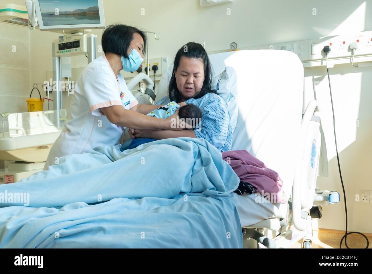 Hebamme hilft Neugeborenen und Mutter, wie man auf Labor Zimmer Krankenhaus wad stillen Stockfoto