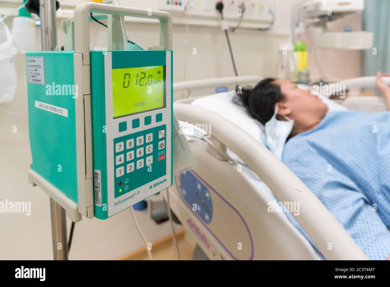 Kota Kinabalu, Sabah, Malaysia-Mai 30. 2020 : Close Up Adjust Infusionspumpe Set iv Flüssigkeit intravenösen Tropfen Kochsalztropfen auf schwangere Frauen Patient im Labor Stockfoto