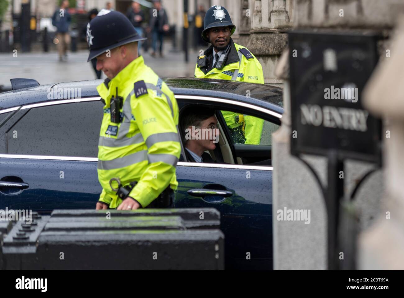 Jacob Rees Mogg fährt mit Polizeibeamten in den Palast von Westminster. Schwarzer männlicher Polizist. Ein Offizier lachend. MP im Auto Stockfoto