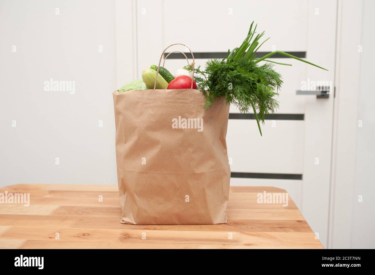 Kontaktlose Produktlieferung an der Tür. Lebensmittel Spende Paket Gemüse, um den Armen zu helfen. Donat-Box mit Lebensmitteln Stockfoto