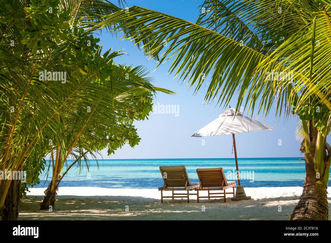 Ruhige Landschaft, erholsamer Strand, tropisches Landschaftsdesign. Sommerurlaub Reise Urlaub Design. Luxusurlaub, Liegen unter Sonnenschirm und Palmen Stockfoto