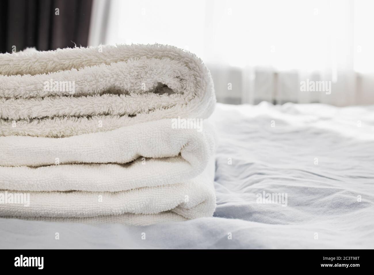 Haufen sauberer weißer Handtücher auf dem Bett Stockfoto