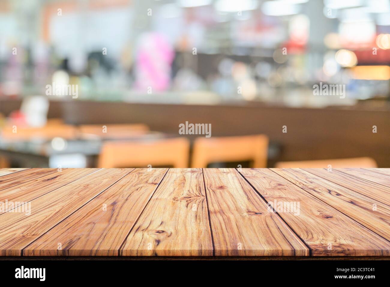 Holztischplatte auf verschwommenem Hintergrund des Innencafés oder Restaurants verwischen Café Café-Shop Hintergrund Stockfoto