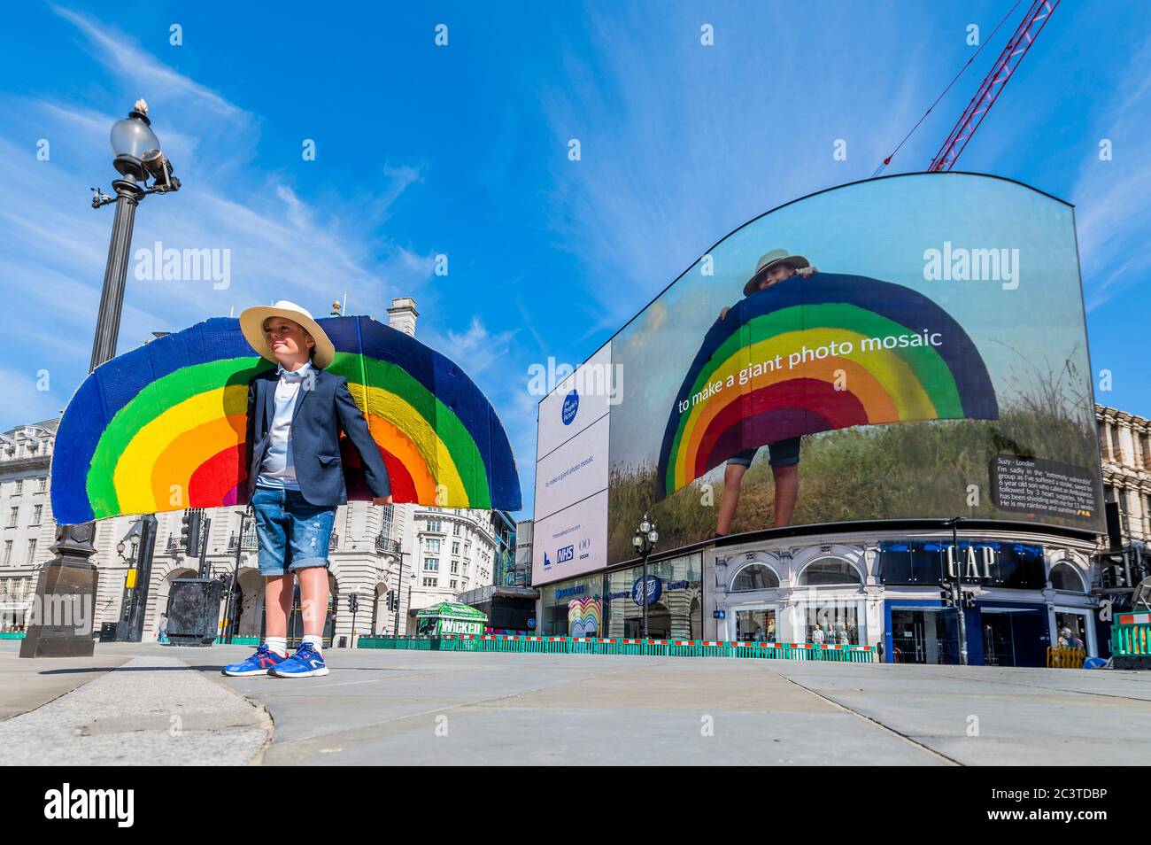 Harry Marsh, 9 Jahre alt, der seine Mutter Suzy Marsh aus London rettete, indem er 999 anwählen konnte, als sie vor drei Jahren einen Schlaganfall hatte und im Royal Brompton Hospital in Chelsea behandelt wurde. ‘das interaktive Mosaikkunstprojekt Rainbows for the NHS von The People's Picture wurde am Londoner Piccadilly Lights ins Leben gerufen und läuft bis Juni 28 - über 12,000 Bilder und Geschichten wurden gesammelt, um als ein riesiges interaktives Stück online betrachtet zu werden, das die Nation von zu Hause aus genießen kann. Das Mosaik zeigt einige der Geschichten aus der ganzen Nation, von Ärzten, Krankenschwestern, Schlüsselarbeitern, Betreuern und einer großen Auswahl an anderen Antworten Stockfoto