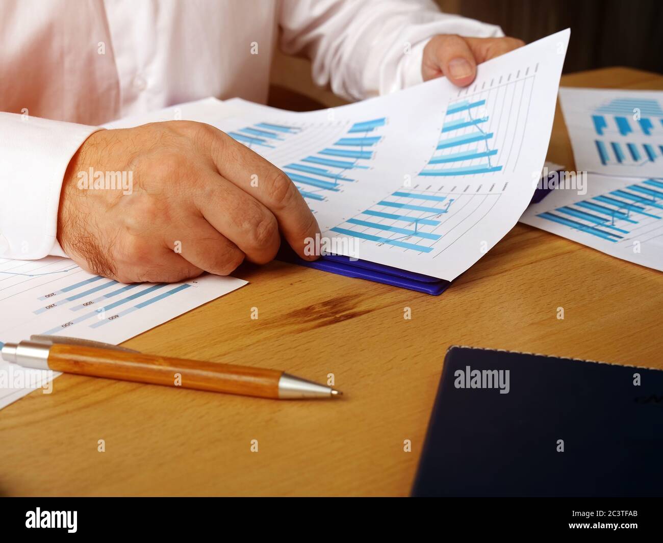 Der Manager prüft einen Bericht mit Diagrammen über die Verkaufshöhe. Stockfoto