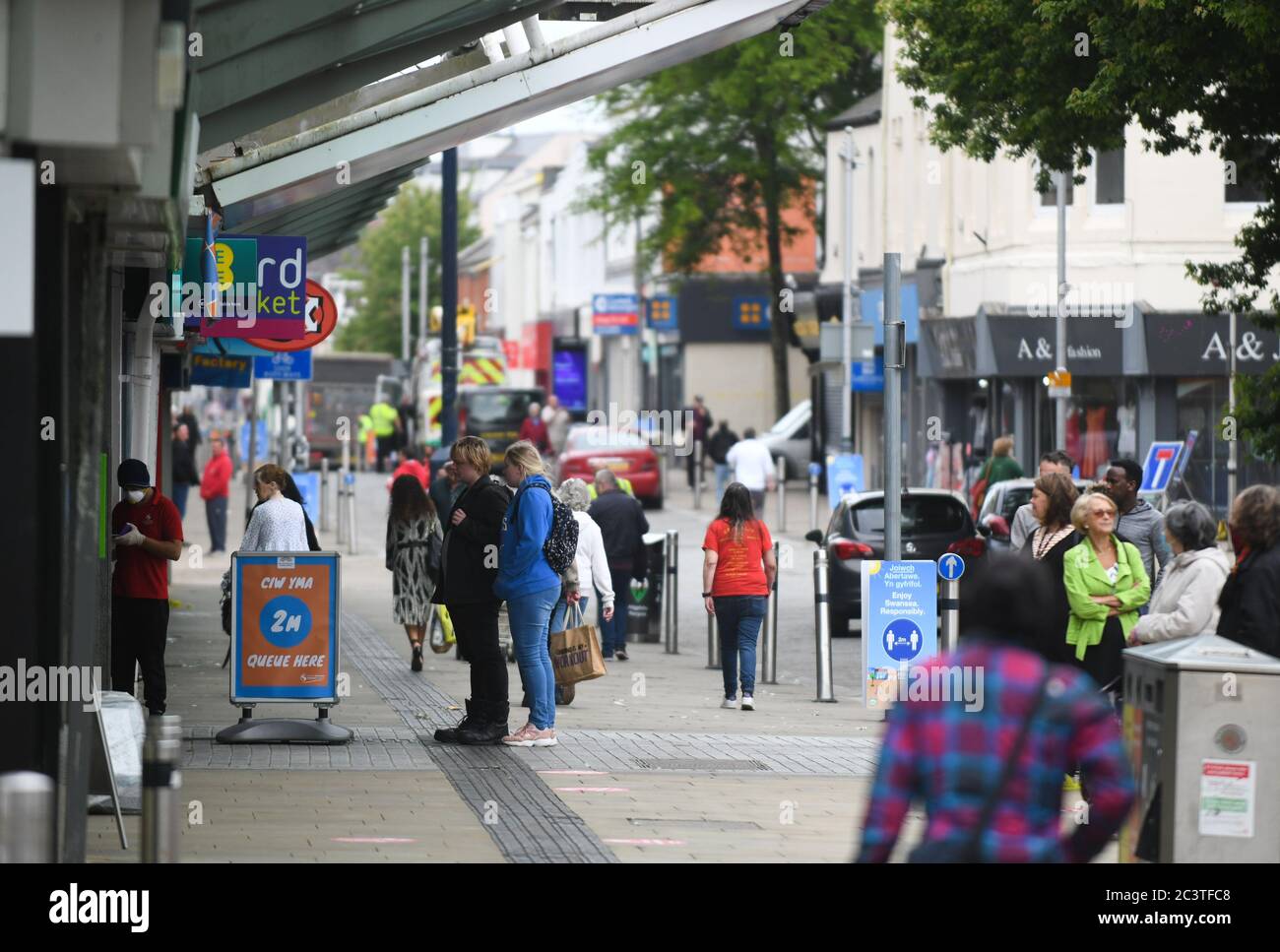Swansea, Wales, Großbritannien. 22. Juni 2020.Menschen auf den Straßen der Oxford Street als nicht-wesentliche Geschäfte öffnen in Swansea, Südwales mit sozialer Distanzierung an Ort und Stelle, da Geschäfte in ganz Wales ihre Türen für Käufer zum ersten Mal öffnen, seit Coronavirus-Beschränkungen wurden in Kraft gesetzt. Es ist eine Woche später, seit nicht-wesentliche Geschäfte in England eröffnet. Kredit : Robert Melen/Alamy Live Nachrichten Stockfoto