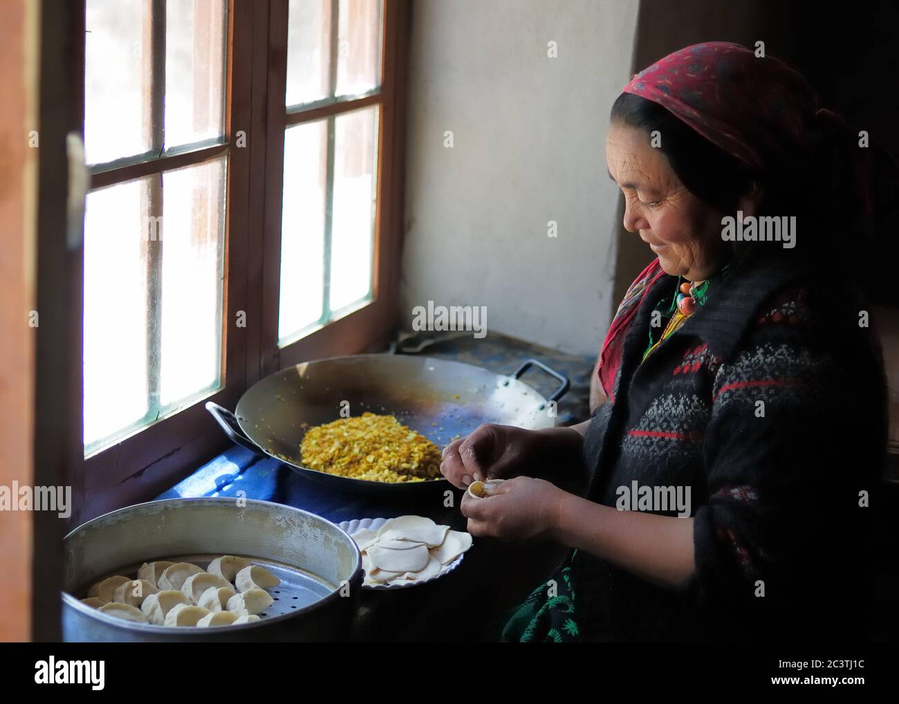 Nubra Valley, Indien - Juli 10: Ladakhi Frau bereitet traditionelle Momo Knödel am Fenster in der eigenen Küche, am 10. Juli 2017 Stockfoto