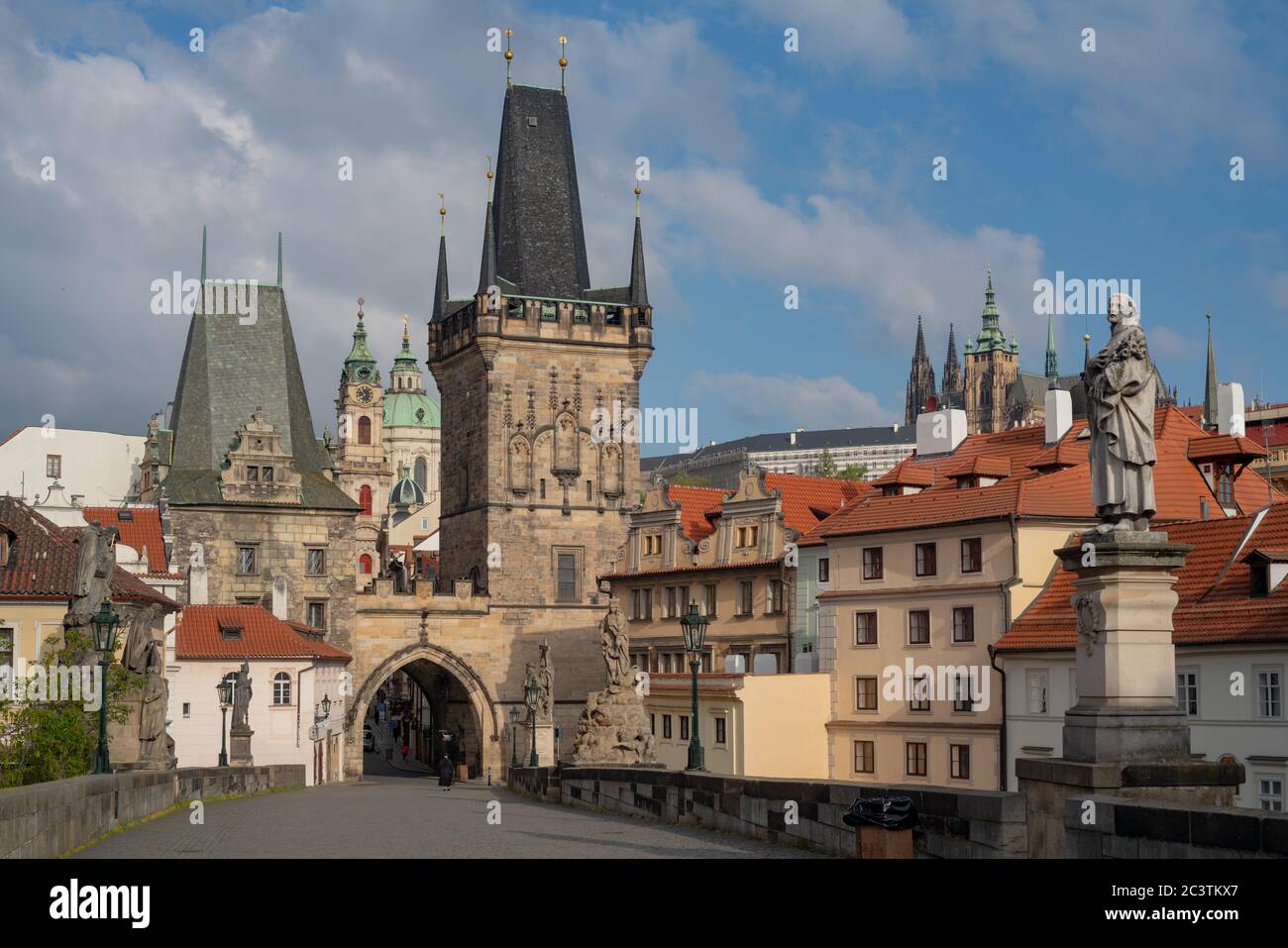 Brückenkopf der Karlsbrücke mit gotischem Tor und Türmen. Die Nikolaikirche und die Prager Burg sind in der Ferne sichtbar. Stockfoto