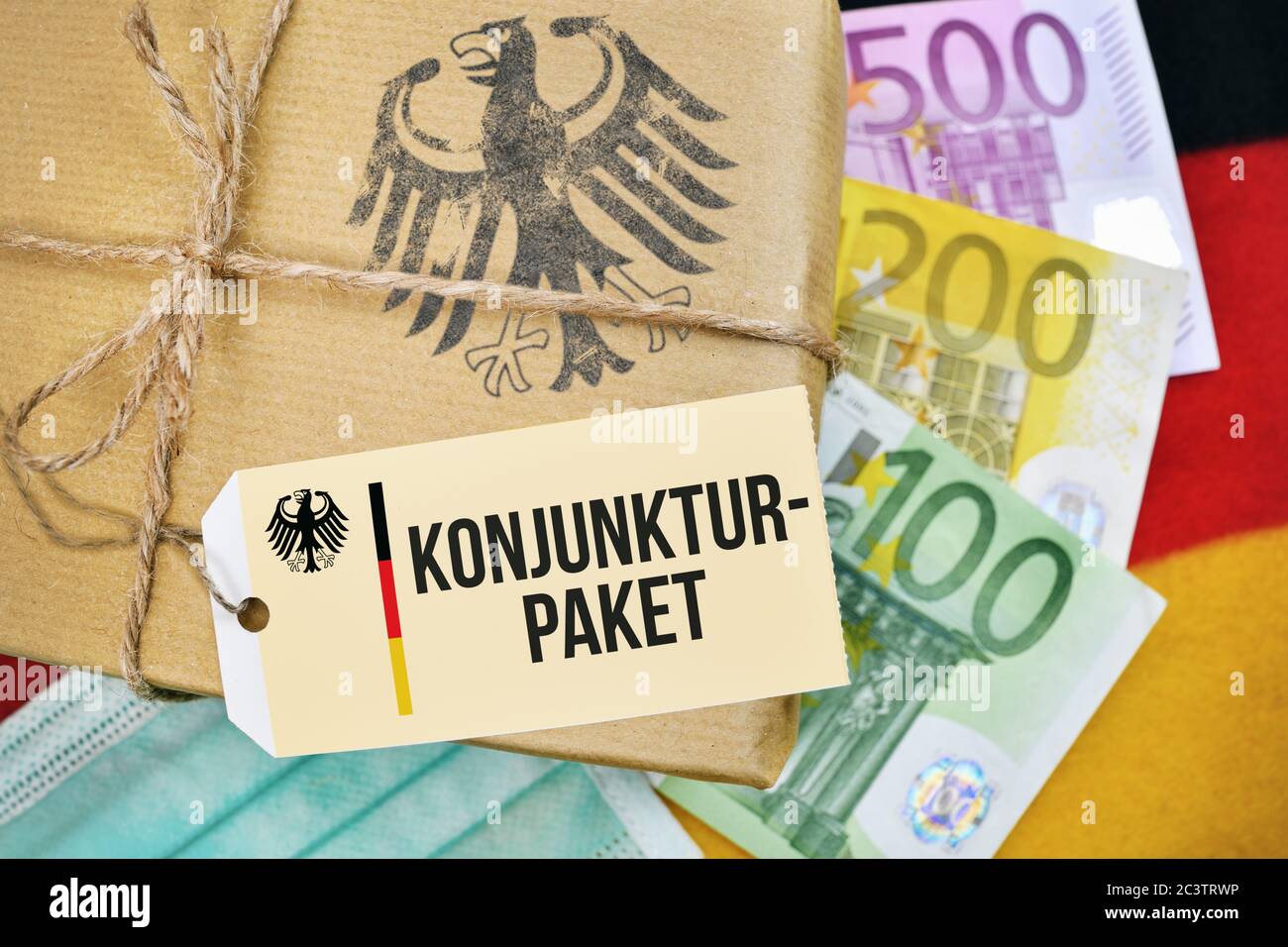 FOTOMONTAGE, Deutschland Paket auf Banner mit dem Label und dem Label Stimulus, FOTOMONTAGE, Paket auf Deutschlandfahne mit Etikett und der Aufschrift Stockfoto