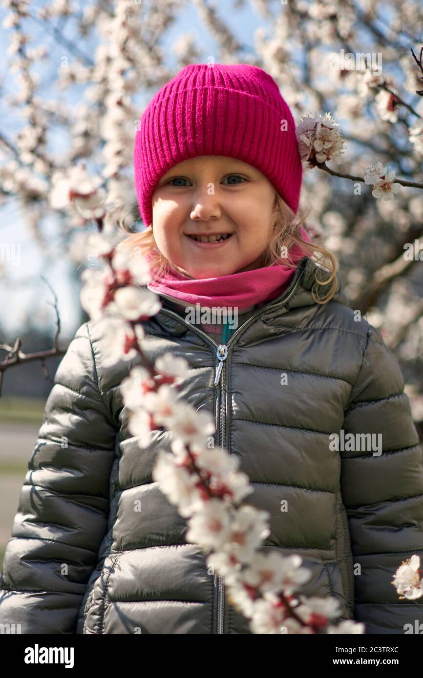 Porträt eines glücklichen liitle Mädchen Nahaufnahme. 3 Yaers Mädchen lächeln in Frühlingsblüten Blumen. Stockfoto