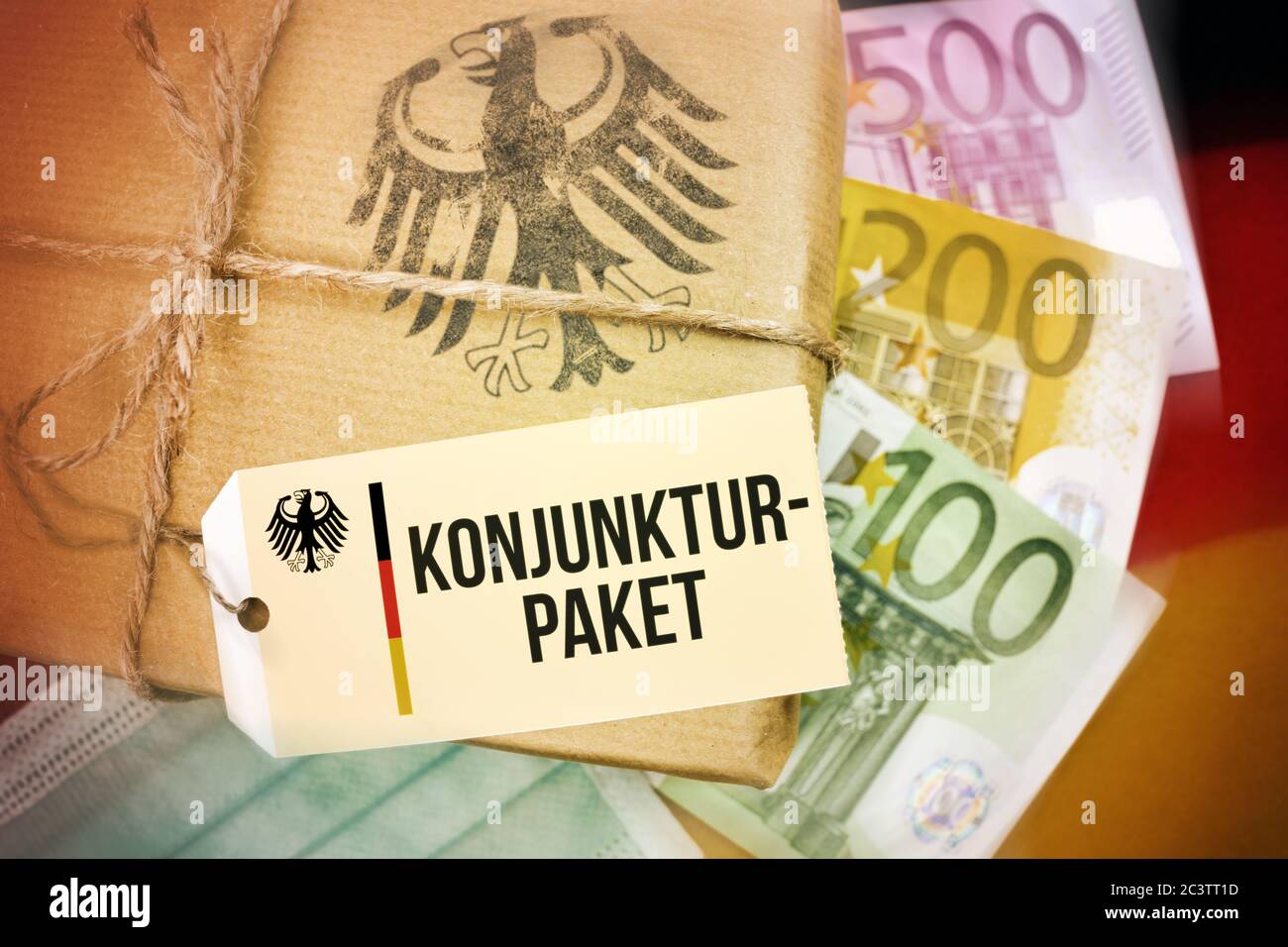 FOTOMONTAGE, Deutschland Paket auf Banner mit dem Label und dem Label Stimulus, FOTOMONTAGE, Paket auf Deutschlandfahne mit Etikett und der Aufschrift Stockfoto